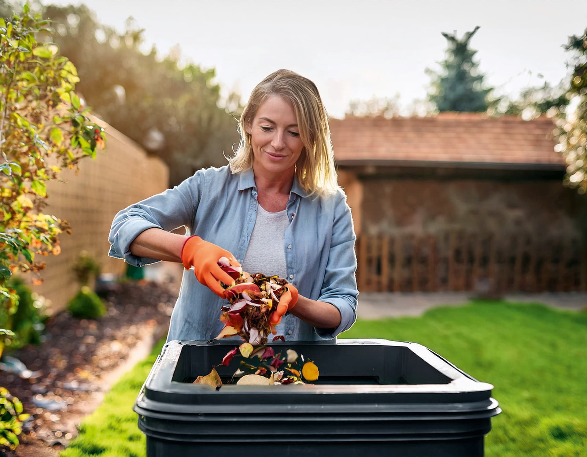 Frau entsorgt Abfälle in einer Biotonne