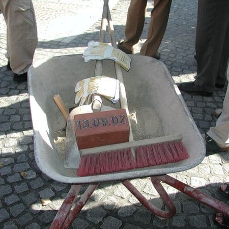 Einweihung Von-der-Mark-Str.: Schubkarre mit Stein und Besen