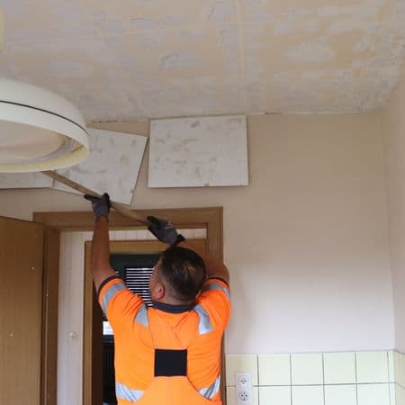 Arbeiter entfernt Deckenkonstruktion