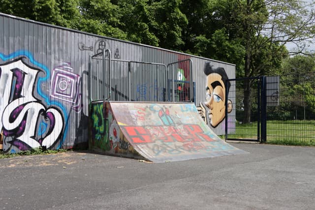 Rampe in einem Skatepark, im Hintergrund Graffitti