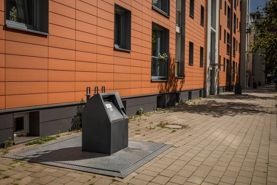 Vollunterflurbehälter Ein grauer Vollunterflurbehälter vor einem Wohnhaus