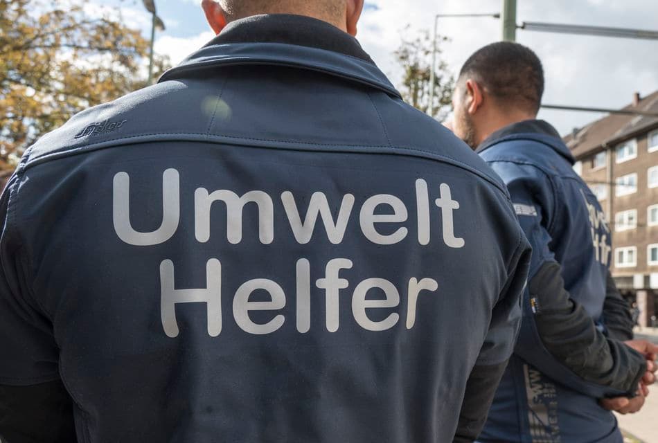 Umwelthelfer Mann mit Jacke auf dessen Rückseite Umwelthelfer steht