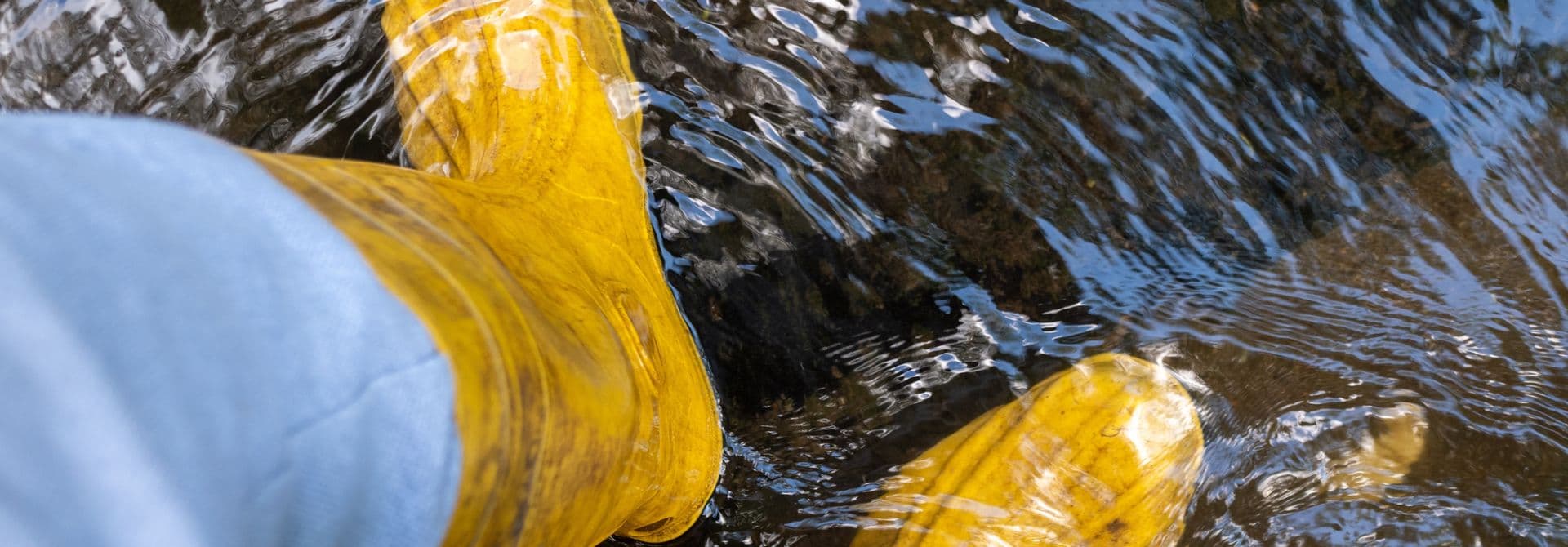 Kellerüberflutung Gelbe Gummistiefel im Wasser